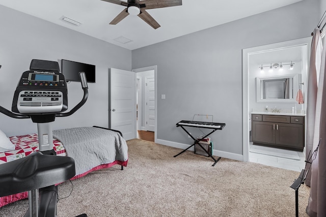 bedroom with connected bathroom, light colored carpet, sink, and ceiling fan