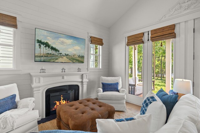 4318 Terebinth Trl, Tallahassee, FL 32317 - living area featuring lofted ceiling, wood finished floors, a lit fireplace, and wooden walls