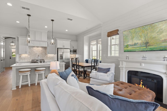 4318 Terebinth Trl, Tallahassee, FL 32317 - living room with light wood finished floors, crown molding, a glass covered fireplace, recessed lighting, and lofted ceiling