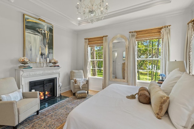 4318 Terebinth Trl, Tallahassee, FL 32317 - bedroom with crown molding, multiple windows, wood finished floors, a glass covered fireplace, and a raised ceiling