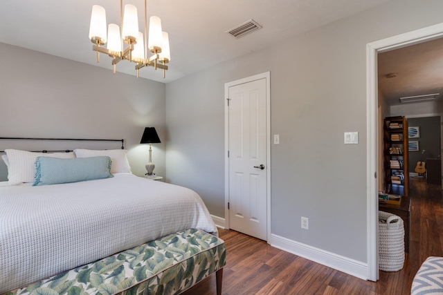 bedroom with dark wood-type flooring and an inviting chandelier