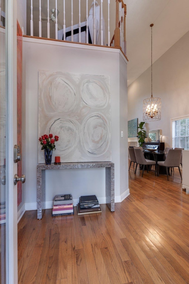 interior space with hardwood / wood-style flooring, high vaulted ceiling, and a notable chandelier