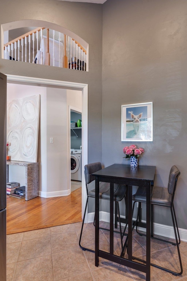 tiled dining area featuring washer / dryer