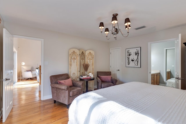 bedroom with a notable chandelier, light hardwood / wood-style flooring, and ensuite bath