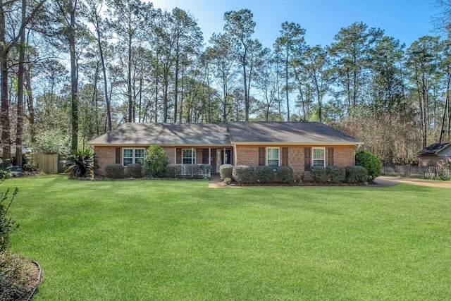 single story home with a front lawn, fence, and brick siding