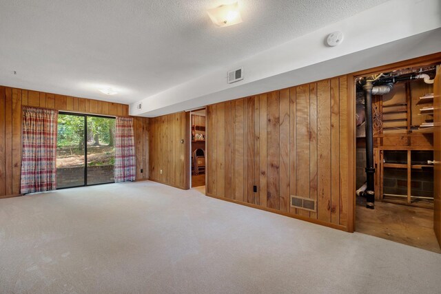2003 Chuli Nene, Tallahassee, FL 32301 - spare room featuring wood walls, carpet, a textured ceiling, and a smoke detector