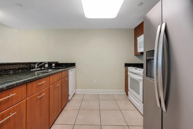 300 S Duval St Unit 612, Tallahassee, FL 32301 - kitchen featuring white appliances, dark stone countertops, light tile patterned flooring, and brown cabinets