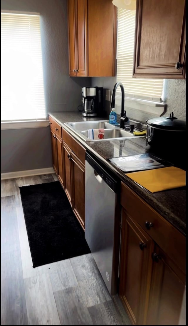 1216 Hidden Pl, Tallahassee, FL 32304 - kitchen featuring a sink, dark countertops, wood finished floors, brown cabinetry, and dishwasher