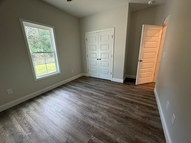 unfurnished bedroom featuring dark hardwood / wood-style floors and a closet