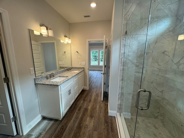 bathroom with walk in shower, vanity, and hardwood / wood-style floors