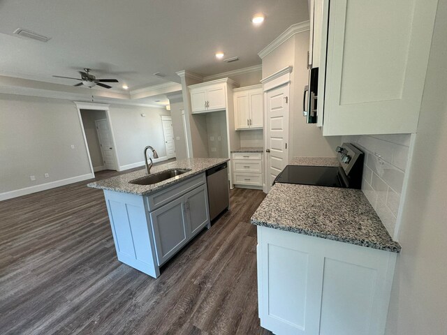 kitchen with stainless steel appliances, sink, a kitchen island with sink, white cabinets, and dark hardwood / wood-style flooring