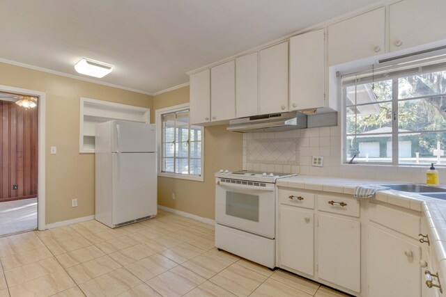 kitchen featuring white cabinets, white appliances, tile counters, and tasteful backsplash