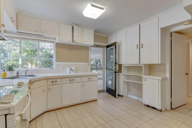 kitchen featuring white cabinets, a healthy amount of sunlight, and ornamental molding