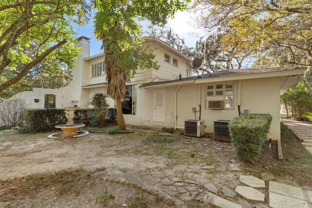 rear view of property featuring central AC unit and cooling unit