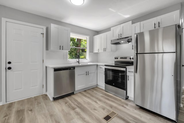 2124 Berkshire Dr, Tallahassee, FL 32304 - kitchen with stainless steel appliances, under cabinet range hood, a sink, and white cabinetry