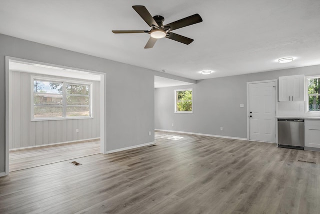2124 Berkshire Dr, Tallahassee, FL 32304 - unfurnished living room with baseboards, a ceiling fan, light wood-type flooring, and healthy amount of natural light