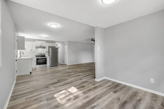 2124 Berkshire Dr, Tallahassee, FL 32304 - unfurnished living room with baseboards, a ceiling fan, and light wood-style flooring
