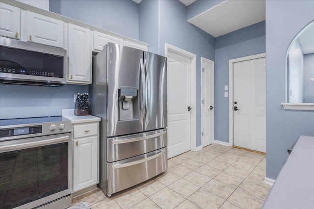 kitchen featuring light countertops, white cabinetry, appliances with stainless steel finishes, and light tile patterned floors
