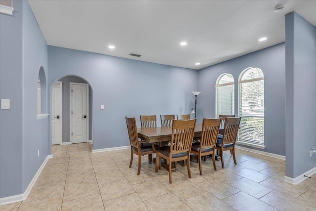 dining area featuring arched walkways, recessed lighting, and visible vents