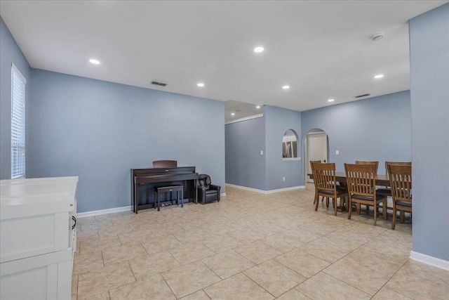 dining room with arched walkways, baseboards, visible vents, and recessed lighting