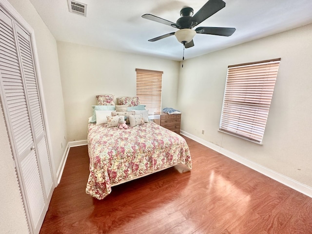 bedroom with hardwood / wood-style flooring, ceiling fan, and a closet