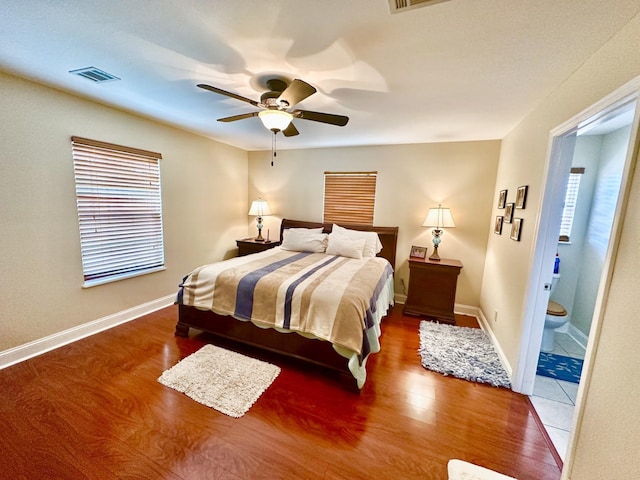 bedroom with wood-type flooring, ensuite bathroom, and ceiling fan