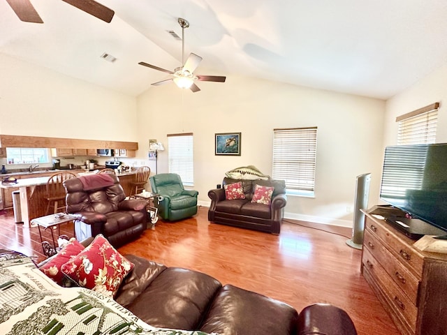 living room featuring high vaulted ceiling, light hardwood / wood-style floors, and ceiling fan