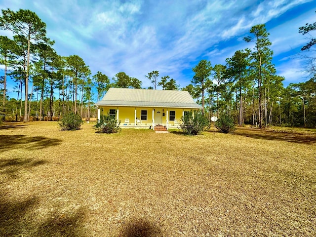 country-style home featuring a front yard and covered porch