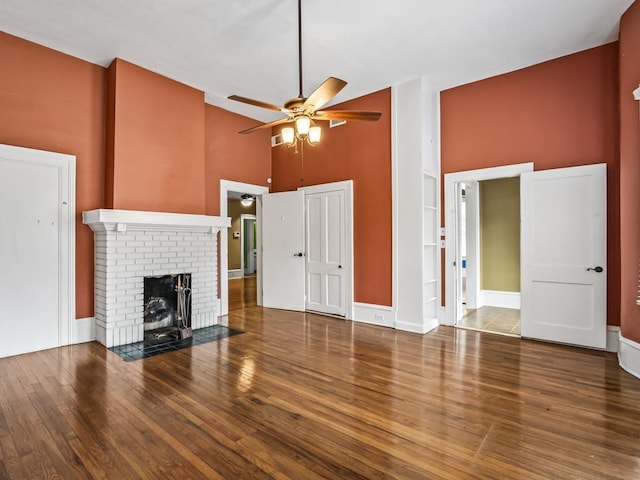 unfurnished living room with hardwood / wood-style floors, a fireplace, high vaulted ceiling, and ceiling fan