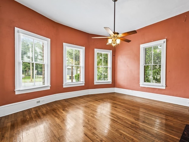 spare room featuring plenty of natural light, hardwood / wood-style floors, and ceiling fan