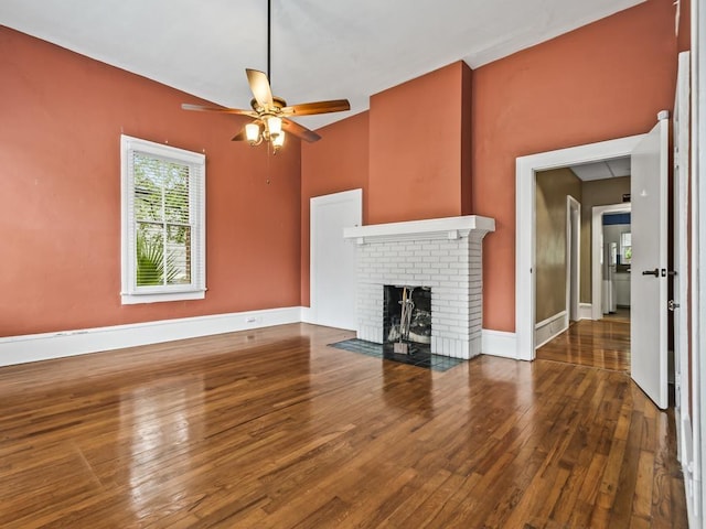 unfurnished living room with ceiling fan, a fireplace, and wood-type flooring