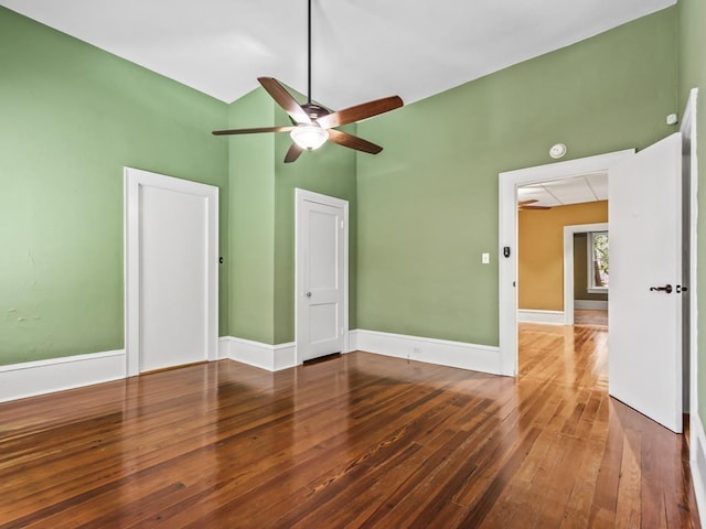 unfurnished room with ceiling fan, lofted ceiling, and dark hardwood / wood-style flooring