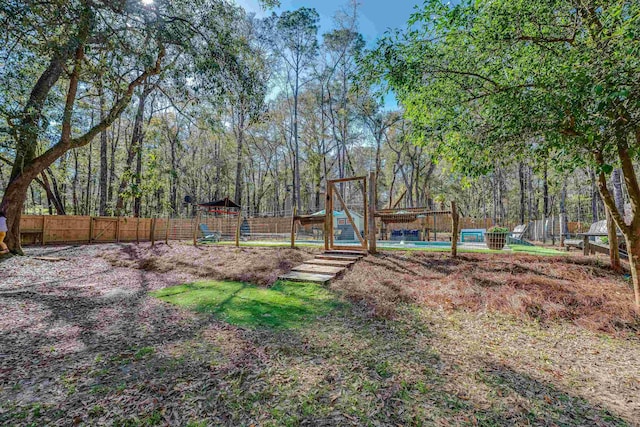 view of yard with a view of trees and fence