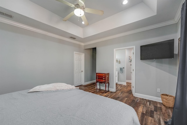 bedroom featuring visible vents, a raised ceiling, baseboards, and wood finished floors