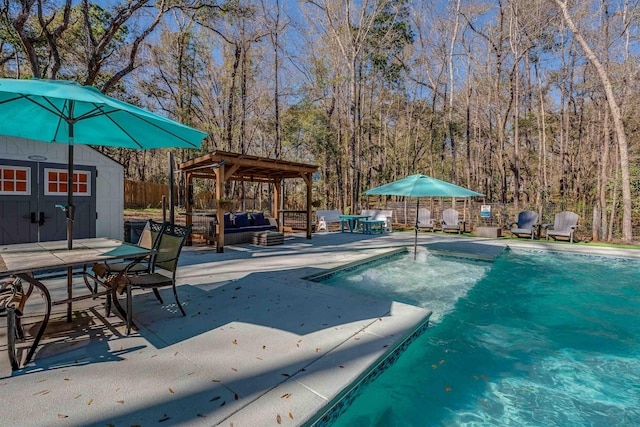 view of pool featuring fence, outdoor dining area, a patio area, a storage unit, and an outbuilding