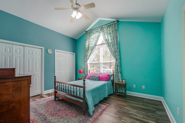 bedroom with baseboards, multiple closets, wood finished floors, and vaulted ceiling