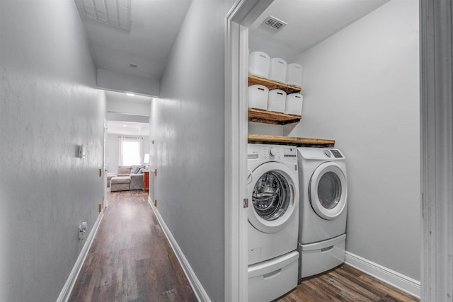 washroom featuring visible vents, independent washer and dryer, laundry area, baseboards, and dark wood-style flooring