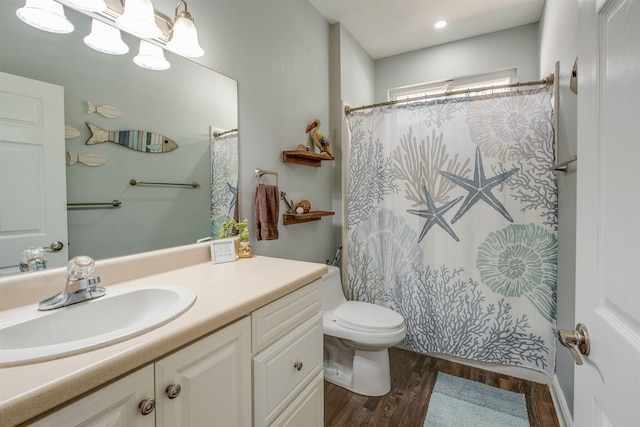 bathroom featuring toilet, a shower with curtain, wood finished floors, a notable chandelier, and vanity