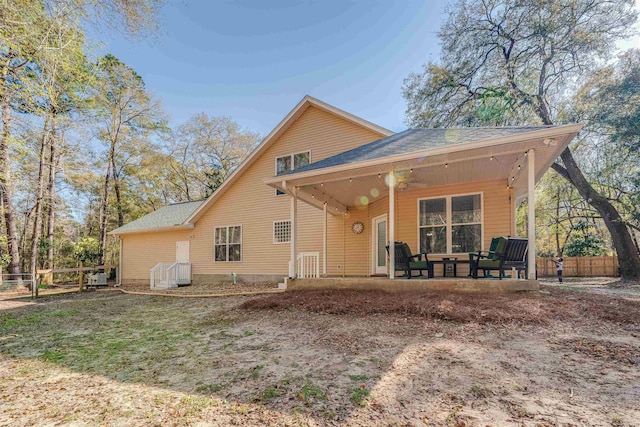 rear view of property featuring a patio area and fence