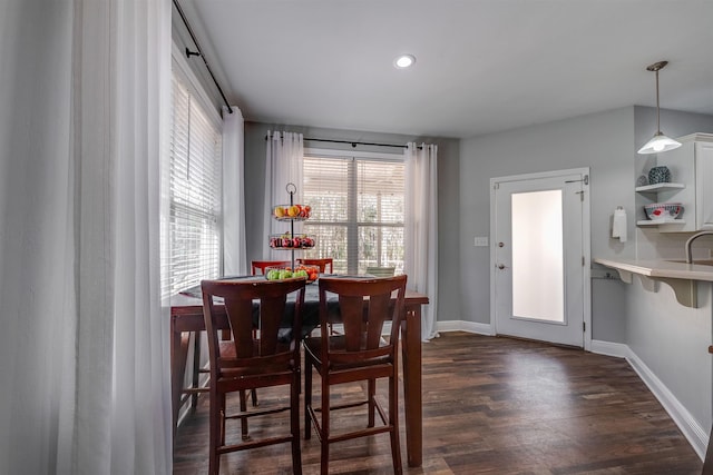 dining space with dark wood finished floors, recessed lighting, and baseboards