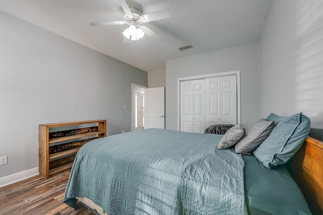 bedroom featuring visible vents, ceiling fan, baseboards, wood finished floors, and a closet