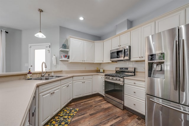 kitchen with tasteful backsplash, appliances with stainless steel finishes, light countertops, and a sink