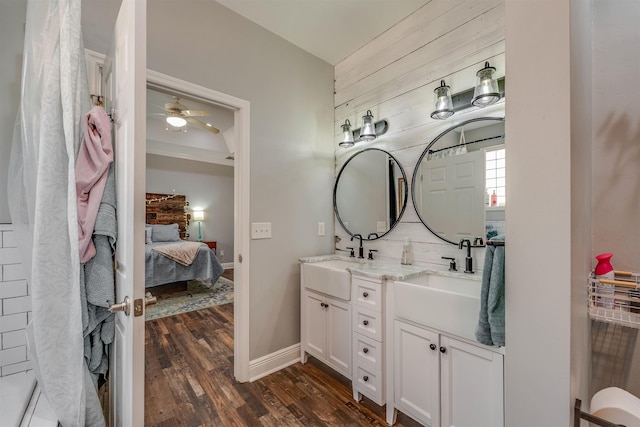 bathroom featuring a sink, double vanity, wood finished floors, and ensuite bathroom