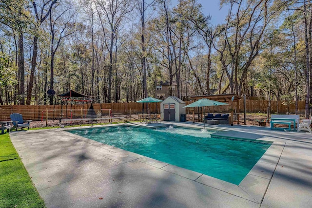 view of pool with a patio, a fenced in pool, a fenced backyard, an outdoor structure, and a storage unit