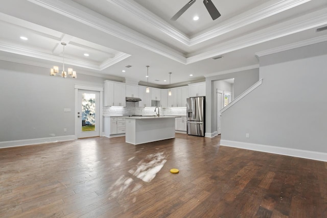 kitchen with dark hardwood / wood-style flooring, a center island with sink, hanging light fixtures, white cabinetry, and stainless steel fridge