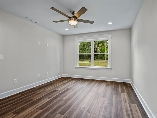 empty room featuring recessed lighting, visible vents, dark wood finished floors, and baseboards