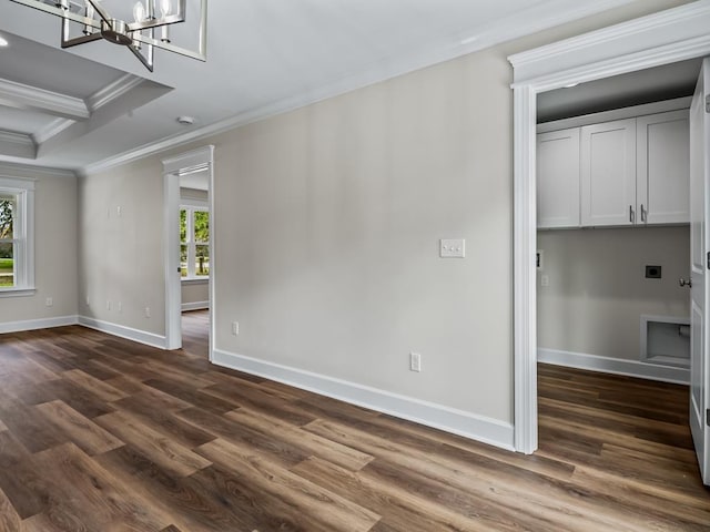 empty room featuring dark wood-style floors, ornamental molding, a notable chandelier, and baseboards