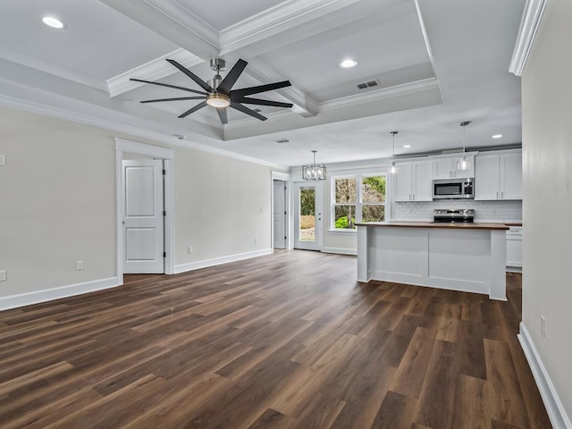 unfurnished living room with visible vents, baseboards, beam ceiling, dark wood finished floors, and crown molding