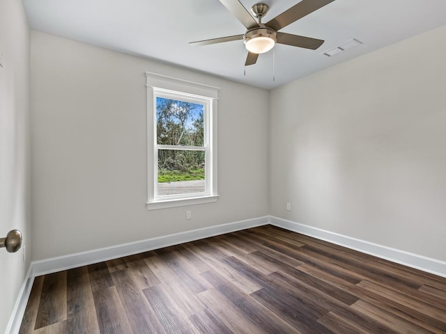 empty room featuring dark wood-style floors, visible vents, baseboards, and a ceiling fan