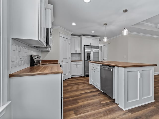 kitchen with butcher block countertops, stainless steel appliances, white cabinets, and hanging light fixtures